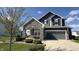 Inviting two-story home with gray siding, stone accents, well-kept landscaping, and an attached two-car garage at 15406 Forest Glade Dr, Fishers, IN 46037