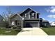 Beautiful two-story home with gray siding, stone accents, well-manicured lawn, and an attached two-car garage at 15406 Forest Glade Dr, Fishers, IN 46037