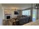 Comfortable living room with a stone fireplace, modern decor, and a view into the breakfast nook at 15406 Forest Glade Dr, Fishers, IN 46037
