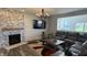 Well-lit living room featuring a stone fireplace, contemporary decor, and comfortable seating arrangements at 15406 Forest Glade Dr, Fishers, IN 46037