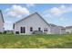 A spacious backyard with a hot tub and grill on the patio and green grass at 1666 Huntzinger Blvd, Pendleton, IN 46064
