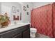 Bathroom with framed art on the walls, a vanity, and a red patterned shower curtain at 1666 Huntzinger Blvd, Pendleton, IN 46064