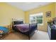 Bedroom with yellow walls, a metal frame bed, and natural light from the large window at 1666 Huntzinger Blvd, Pendleton, IN 46064