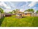 Spacious backyard with a pergola, a shed, green grass and a brick house at 1823 E 44Th St, Anderson, IN 46013
