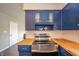 Updated kitchen showcasing blue cabinets, butcher block countertops, and stainless steel stove at 1823 E 44Th St, Anderson, IN 46013