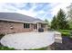 Well-manicured backyard featuring a stone patio with black mulch beds and brick home at 1893 Water Oak Way, Avon, IN 46123