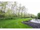 Sprawling backyard featuring a lush lawn, landscaping, and mature trees at 1893 Water Oak Way, Avon, IN 46123