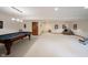 Spacious finished basement with a pool table, lounge chair, and door at 1893 Water Oak Way, Avon, IN 46123