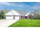 Beautiful brick ranch home featuring a spacious three-car garage and a well-manicured lawn at 1893 Water Oak Way, Avon, IN 46123