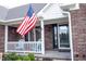 American flag on the front porch with blue Adirondack chairs creates a welcoming entrance to the home at 1893 Water Oak Way, Avon, IN 46123