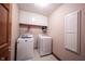 Functional laundry room with washer, dryer, storage cabinets, and neutral flooring at 1893 Water Oak Way, Avon, IN 46123