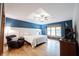 Primary bedroom featuring high tray ceilings, blue accent wall, and window seat at 1893 Water Oak Way, Avon, IN 46123