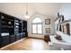 Bright office boasts built-in bookcases, arched window, hardwood floors, and writing desk at 1893 Water Oak Way, Avon, IN 46123