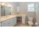 Bathroom with white cabinets and drawers, white toilet, corner writing desk and large vanity mirror at 1920 E 81St St, Indianapolis, IN 46240