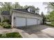 Charming garage with white brick, dormer, black roof, carriage doors, and concrete driveway at 1920 E 81St St, Indianapolis, IN 46240