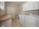 Well-organized laundry room with sleek cabinets and countertop, next to a toilet room at 1920 E 81St St, Indianapolis, IN 46240