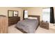 Comfortable bedroom with matching wood furniture and a soft gray duvet cover at 2260 Quarter Path Rd, Cicero, IN 46034