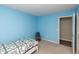 Bright bedroom features blue walls, neutral carpet, and a white framed bed with a decorative quilt at 2260 Quarter Path Rd, Cicero, IN 46034
