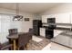 Modern eat-in kitchen area with black appliances, white cabinets, and modern light fixture at 2260 Quarter Path Rd, Cicero, IN 46034