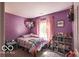 Cozy bedroom featuring purple walls, a comfortable bed, and a charming bookshelf at 2277 Grand Fir Dr, Greenwood, IN 46143