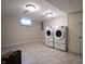 Functional laundry room with appliances, tile floors, and neutral paint at 2305 Caldwell Pl, Columbus, IN 47201