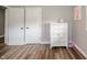 Bedroom featuring modern wood-look floors, two white doors and a white dresser with subtle decorations at 231 N East St, Pendleton, IN 46064