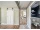 Hallway view features a barn door and a modern half-bath with shiplap accent wall at 231 N East St, Pendleton, IN 46064