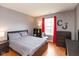 Stylish bedroom with wood floors, neutral walls, and a bright window with red curtains at 2523 Gammon Dr, Indianapolis, IN 46234