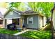 Quaint one-story home with green siding, inviting front porch, and lawn at 321 Harlan St, Indianapolis, IN 46201