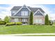 Charming two-story home with a brick and blue facade, beautiful landscaping, and inviting front porch at 3387 Keystone Pass, Plainfield, IN 46168