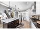 Charming kitchen with dark island, stainless steel appliances, and designer pendant lights at 3387 Keystone Pass, Plainfield, IN 46168
