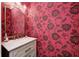 Chic powder room with a modern vanity, marble countertop, and bold floral wallpaper at 3387 Keystone Pass, Plainfield, IN 46168