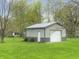 Outbuilding with a garage door and an entry door surrounded by a green lawn and trees at 3710 E 750 S, Lebanon, IN 46052