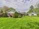 Landscaped backyard featuring a well-maintained lawn and mature trees at 3824 Oakwood Blvd, Anderson, IN 46011