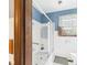 White tiled bathroom with shower, safety bars, and bright window at 3824 Oakwood Blvd, Anderson, IN 46011