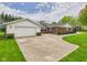 Exterior view showcasing the home's attached garage and expansive driveway at 3824 Oakwood Blvd, Anderson, IN 46011