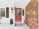 Inviting front porch with a red door, brick accents, and decorative touches at 3824 Oakwood Blvd, Anderson, IN 46011