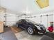 Spacious two car garage featuring ample lighting, a black Cadillac, and white doors for convenience at 3824 Oakwood Blvd, Anderson, IN 46011