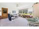 Bright sunroom with large windows offering backyard views, neutral carpet, ceiling fan, and comfortable seating at 3824 Oakwood Blvd, Anderson, IN 46011