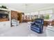 Inviting sunroom features brick accents, neutral carpet, large windows, and comfortable arm chairs at 3824 Oakwood Blvd, Anderson, IN 46011