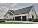 Spacious two-car garage with black doors, white siding, and brick accent, offering ample parking at 3932 Besbie Way, Bargersville, IN 46106