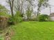 Spacious backyard features a lush green lawn and a partially fenced border at 411 Mccullen St, Chesterfield, IN 46017