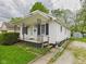 Charming home featuring white siding, a cozy front porch, and a beautifully landscaped front yard with green lawn at 411 Mccullen St, Chesterfield, IN 46017