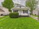 Charming home featuring a well-maintained lawn and a welcoming front porch with decorative iron supports at 411 Mccullen St, Chesterfield, IN 46017
