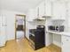 Bright kitchen featuring white cabinetry, stainless steel appliances and laminate flooring at 411 Mccullen St, Chesterfield, IN 46017