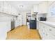 Bright kitchen featuring white cabinetry, stainless steel appliances and laminate flooring at 411 Mccullen St, Chesterfield, IN 46017