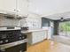 Bright kitchen featuring white cabinetry, appliances, and a view to the backyard with sliding door at 411 Mccullen St, Chesterfield, IN 46017