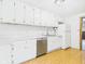 Bright kitchen featuring white cabinetry, stainless steel appliances and laminate flooring at 411 Mccullen St, Chesterfield, IN 46017