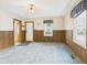 Spacious living room with wood paneling, carpet, and natural light from the windows with decorative valances at 411 Mccullen St, Chesterfield, IN 46017