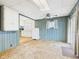 View of the living room with wood paneling next to the kitchen at 411 Mccullen St, Chesterfield, IN 46017